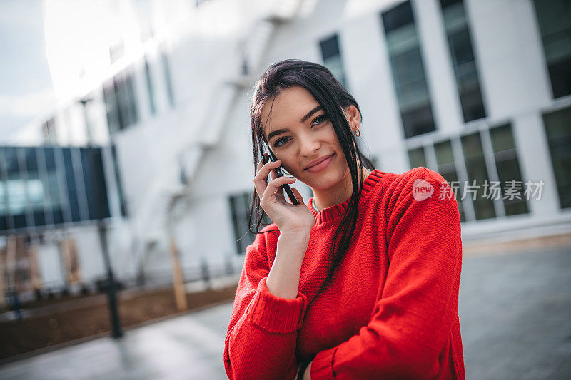 快活的女人在街上用手机