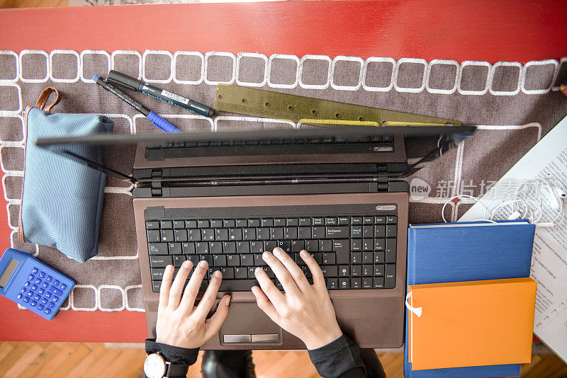 一名十几岁的学生打开笔记本电脑上在线课程