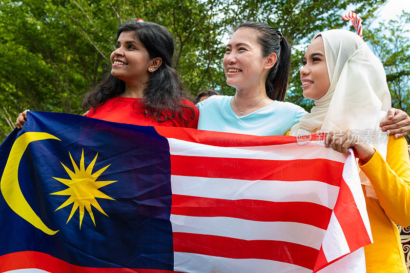马来西亚各族青年在庆祝马来西亚国庆日的活动中，自豪地展示他们的爱国精神和团结精神