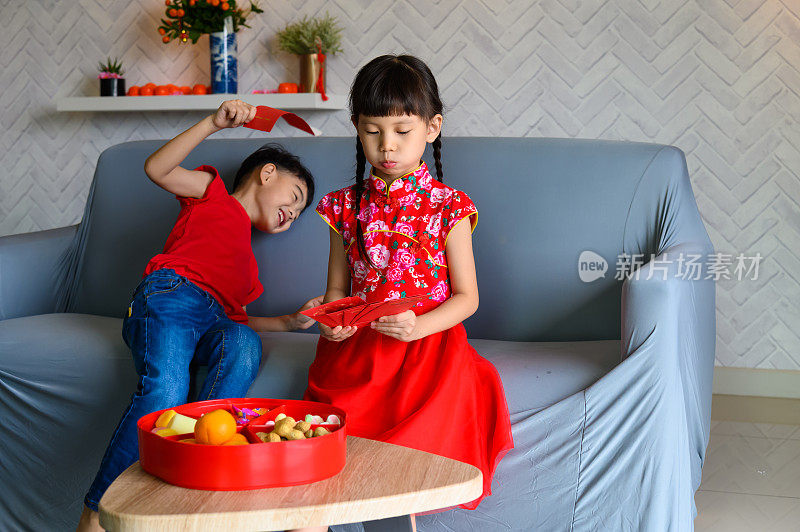 在春节期间，小男孩和小女孩从他们的父母和祖父母那里收到了很多红包(angpow)，他们感到兴奋和高兴。