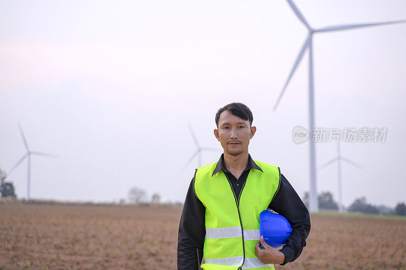 电力工地的蓝领工人。风车。