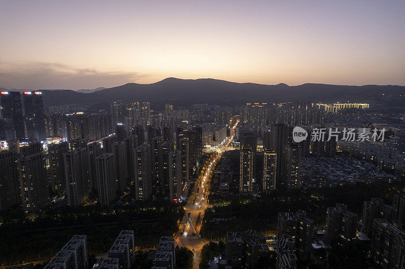 霓虹灯和车流在夕阳的照耀下穿过城市的街道