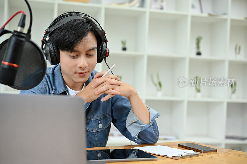 专业的亚洲男性播客或电台主持人集中运行他的播客节目