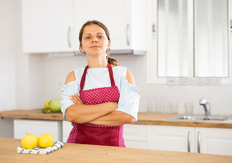 穿着围裙的年轻女子在厨房摆姿势