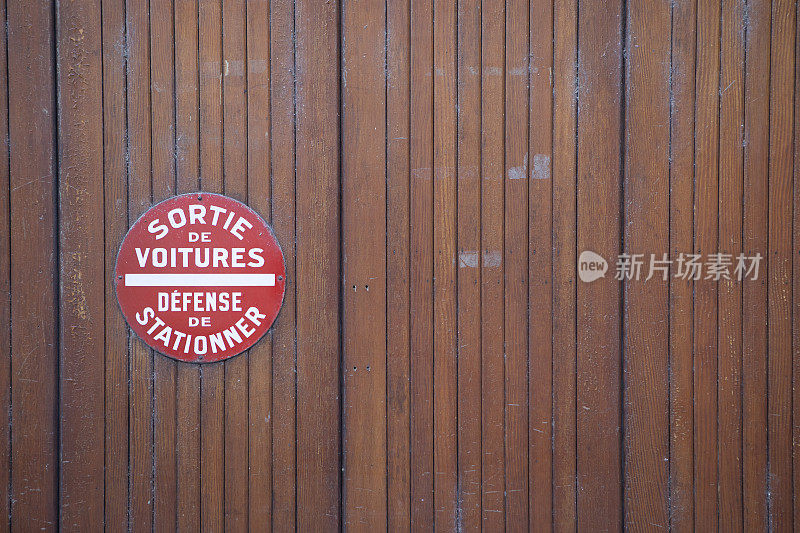 木制车库门上有禁止停车的标志，有复印空间