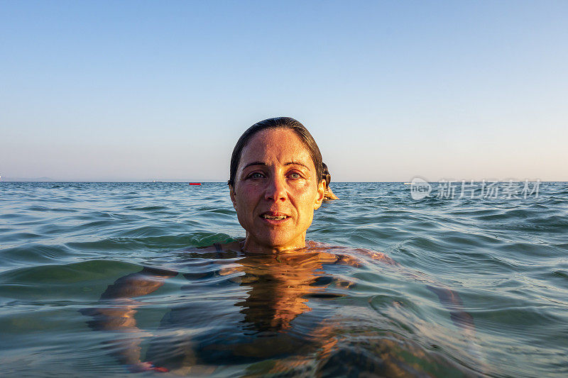 美丽的女人在海里游泳