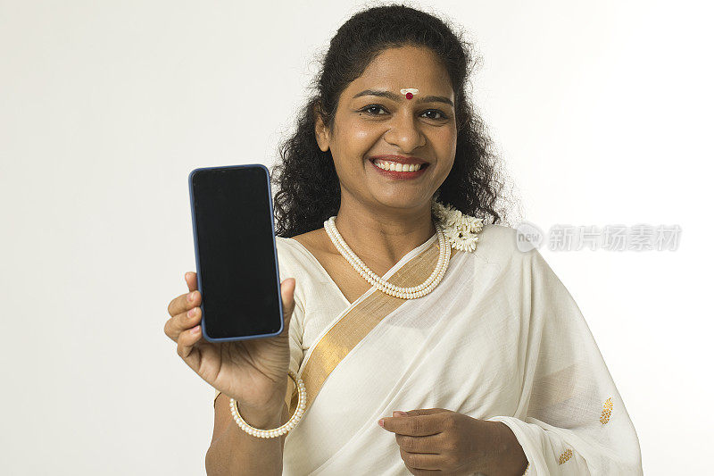 微笑的南印度妇女在纱丽显示空白的手机屏幕