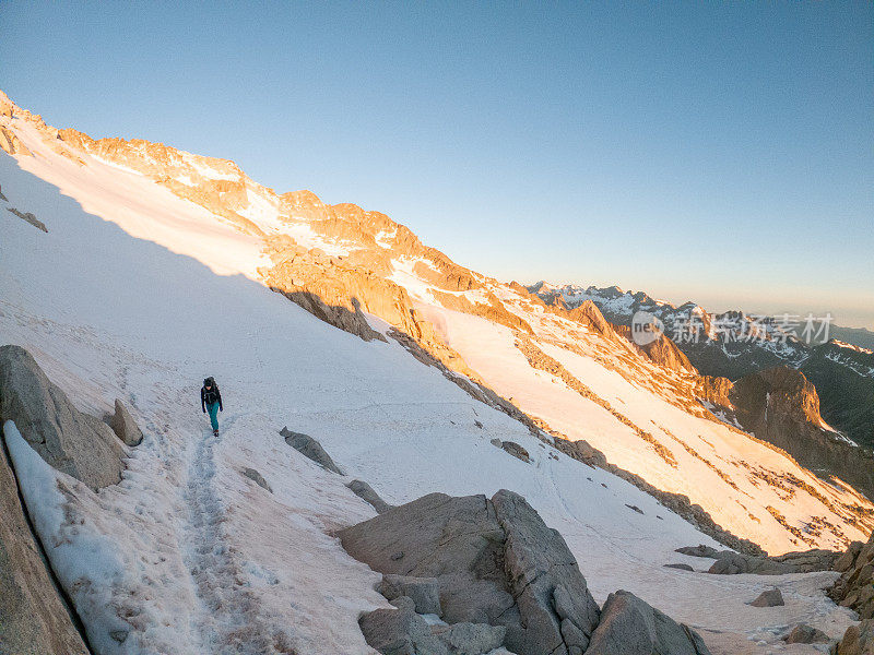 女登山者在雪道上攀登山峰