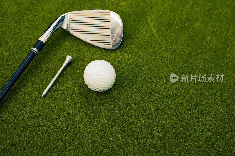 一个高尔夫俱乐部的特写，球，和一个在草地上的发球与复制空间