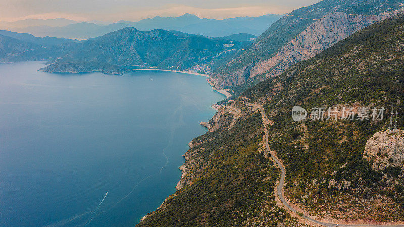 鸟瞰风景优美的山路，沿着水晶蓝色的大海在Oludeniz，土耳其