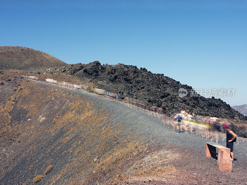 徒步旅行者正在爬上火山