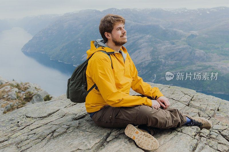 一个快乐的人从挪威风景优美的吕瑟峡湾俯瞰风景