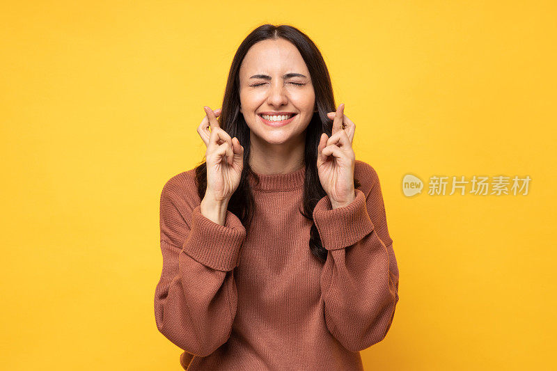 照片的年轻妇女在冬天穿站在黄色背景股票照片