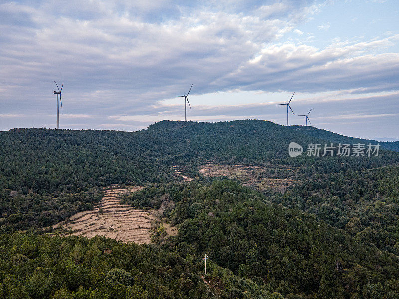 一组风力涡轮机在一个阳光明媚的山上