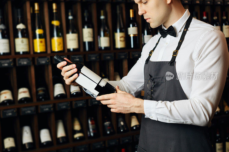 侍酒师在葡萄酒店里向顾客展示一瓶红酒