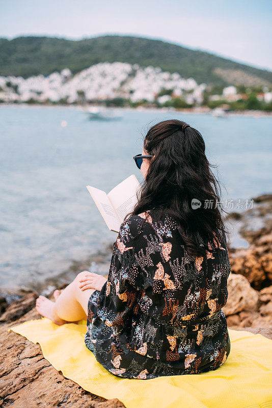 在海滩上看书的女人