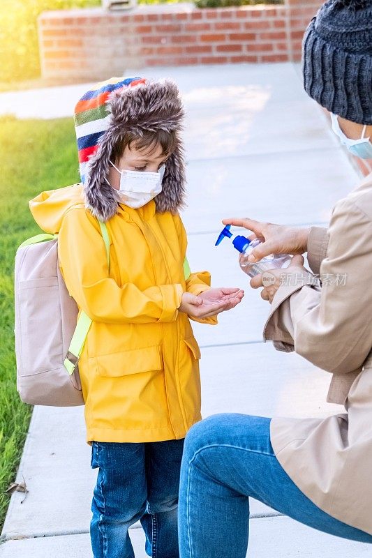 女教师在给学龄前学生使用消毒液