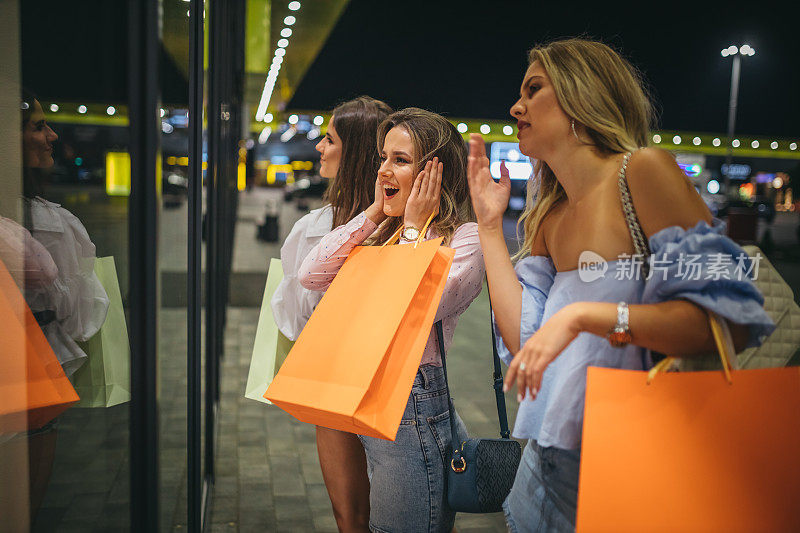 三个女人在看商店的橱窗