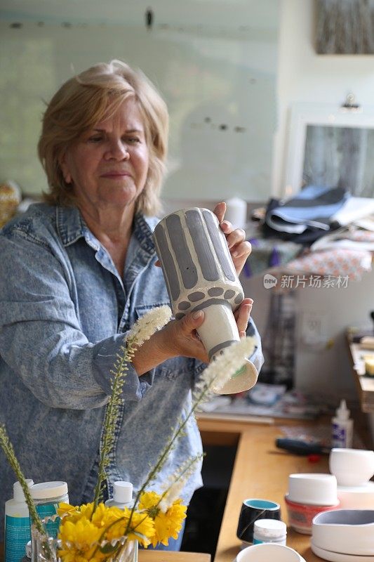 退休妇女在她的作坊里制作陶器