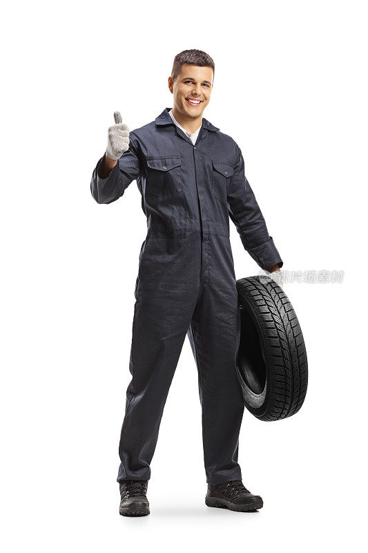 兴高采烈的汽车修理工拿着一个汽车轮胎，竖起大拇指