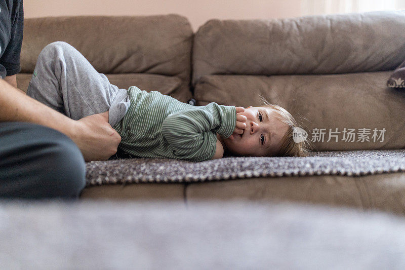 一个可爱的小男孩躺在沙发上的肖像