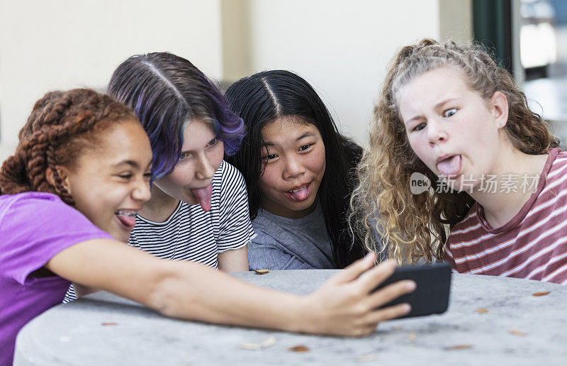 四个少女用智能手机打视频电话