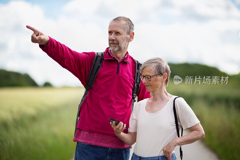 老年夫妇在夏季户外使用手机为定向