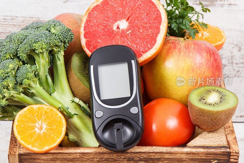 葡萄糖计用于检查糖水平和水果和蔬菜在木盒。糖尿病，饮食和减肥的概念