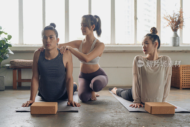 亚洲女瑜伽老师提供肩膀按摩她的学生