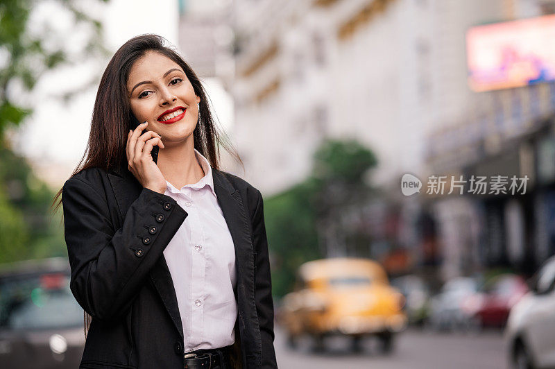 女商人在街上用手机聊天。