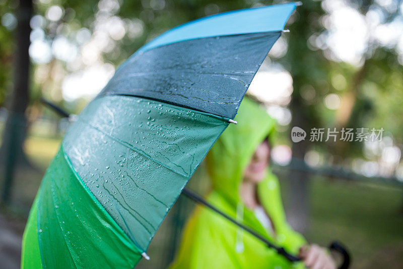 漂亮凉爽的女人带着五颜六色的雨伞在秋天的一天