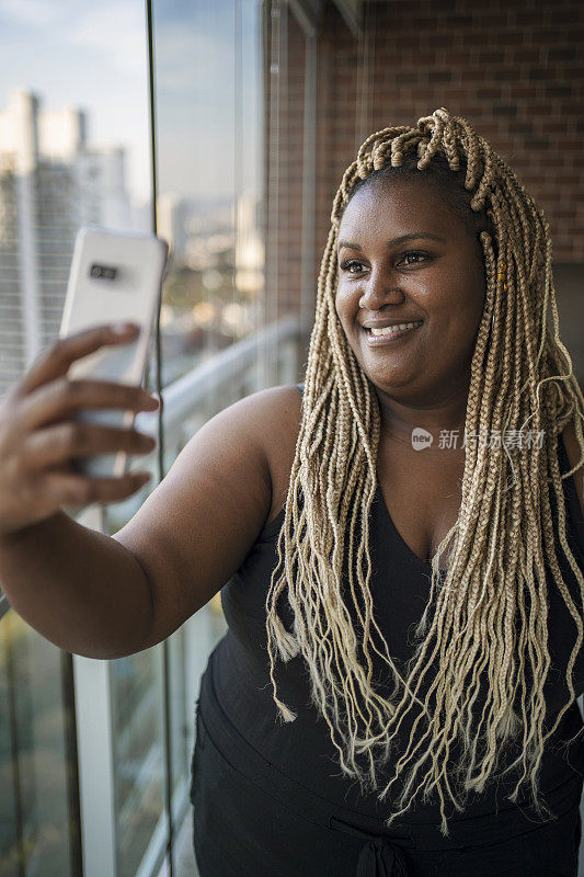 非裔美国美女用智能手机进行在线约会视频通话。