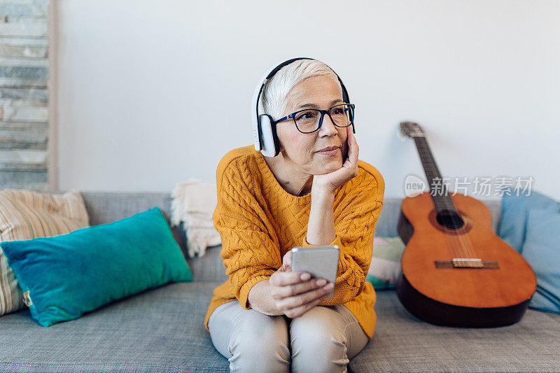 一个年长的女人在家享受她最喜欢的音乐的肖像