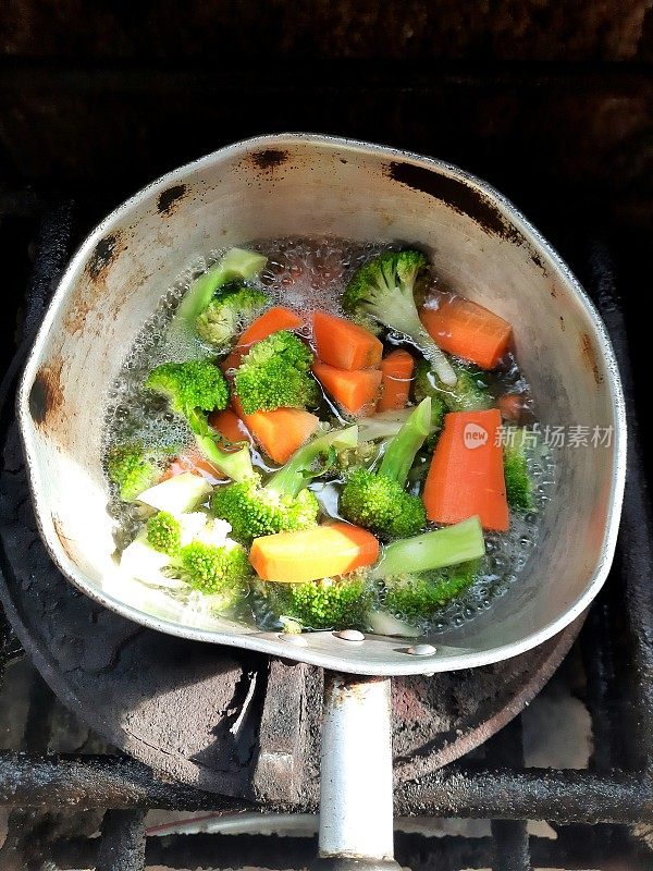 在炉子上用热水煮胡萝卜和花椰菜-食物准备。