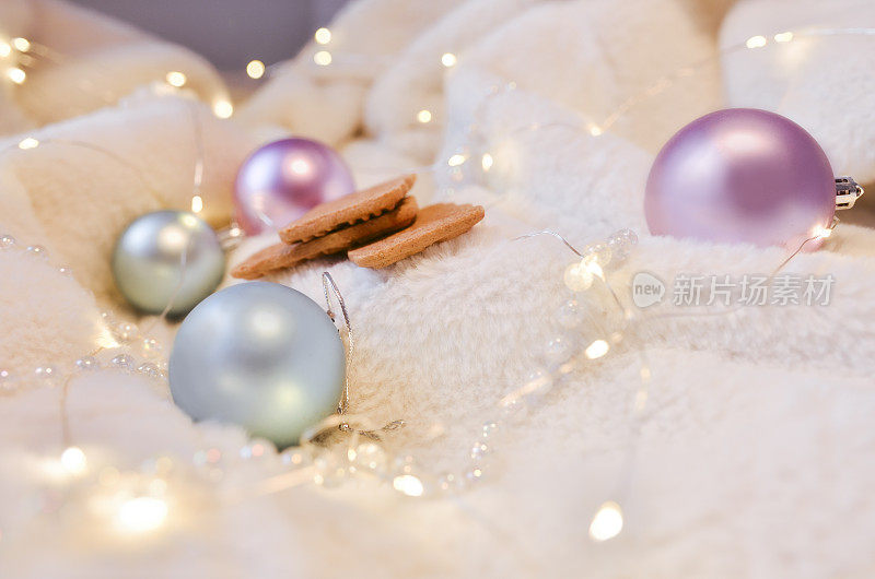 粉红色和蓝色的圣诞装饰品在松软的垫子上