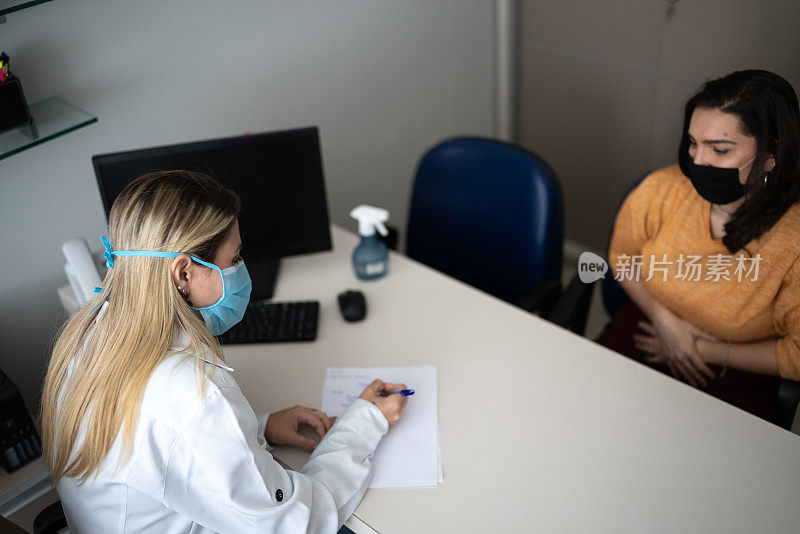 医生戴着防护口罩与预约就诊的病人交谈