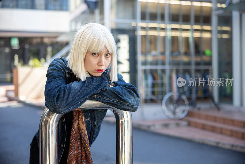 年轻女子的肖像与白金色假发放松在街上