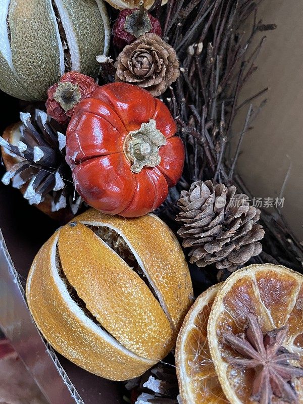 特写图像的圣诞树装饰，干水果花环柑橘水果，干燥的整个和切片橙子，八角和小树枝在纸箱，高架视图
