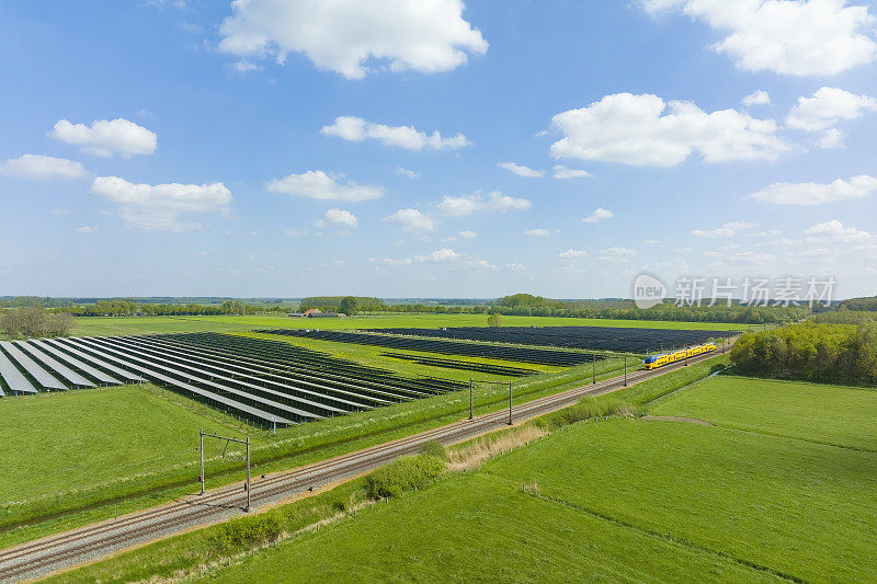 荷兰铁路的火车驶过一片太阳能电池板