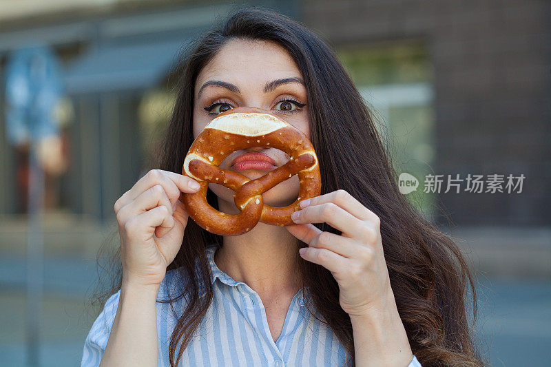 年轻女子正在吃椒盐卷饼