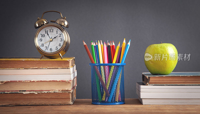 书，苹果，铅笔在木桌上。