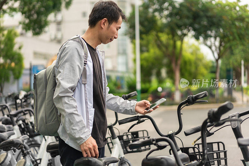 一名男子正在用手机扫描支付共享单车费用