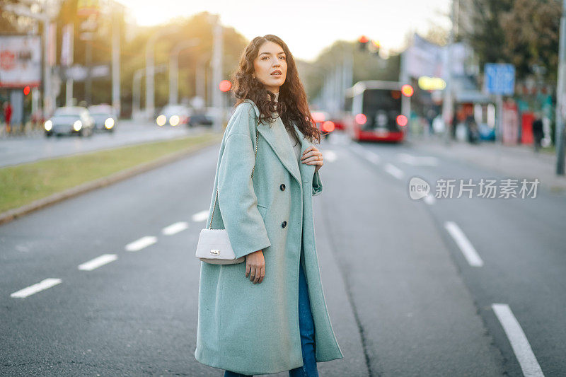 时尚的女人穿过城市的街道