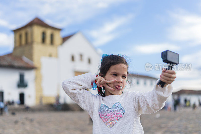 一个拉丁女孩在莱瓦别墅的历史广场用她的GoPro自拍