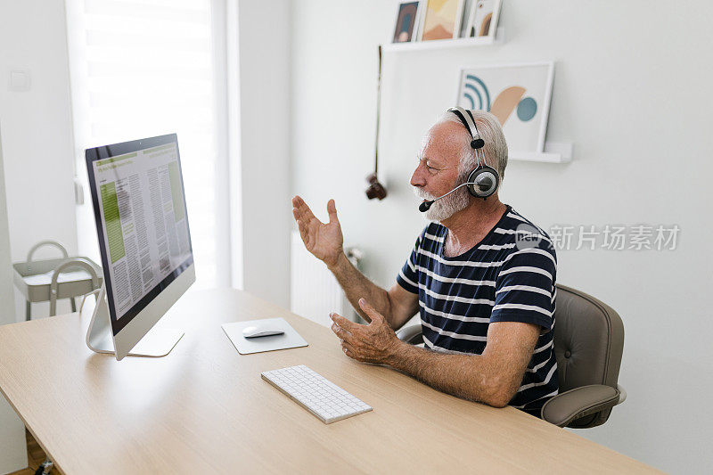 一位老人在呼叫中心工作时使用电脑的镜头