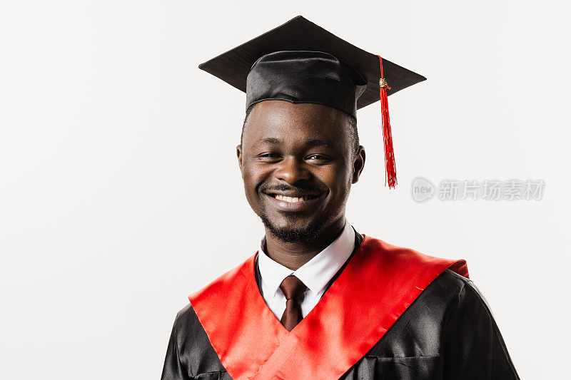 研究生肖像非洲人大学毕业并获得硕士学位。毕业典礼。快乐的非洲男子在黑色毕业长袍是微笑在白色背景。