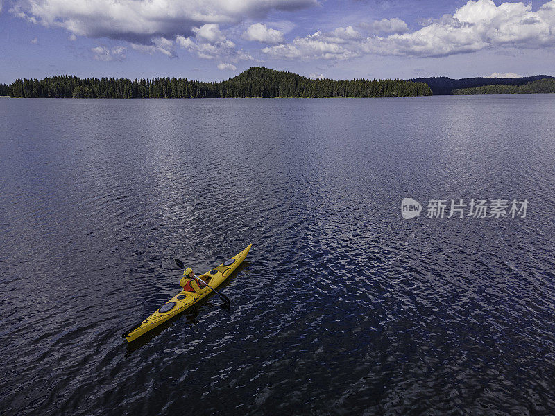 人与自然。女子在湖中划水，鸟瞰图。