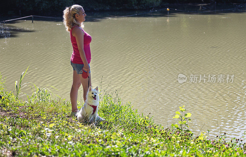 在湖边与宠物狗共度时光的女人