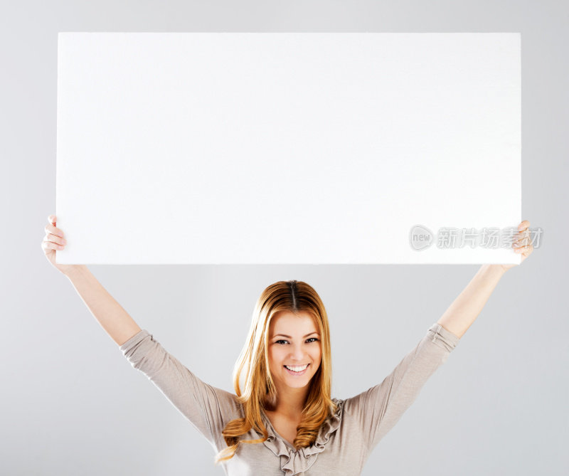 微笑的年轻女子与标志白板。