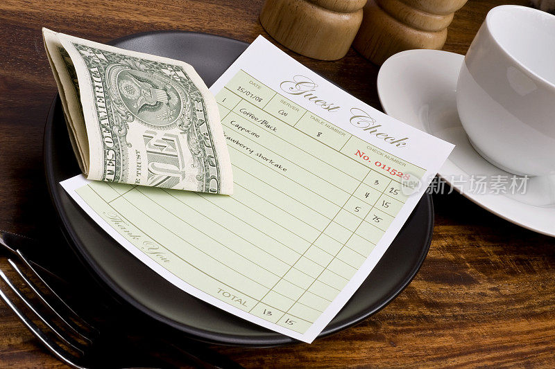 餐厅客人用折叠的美元账单结账